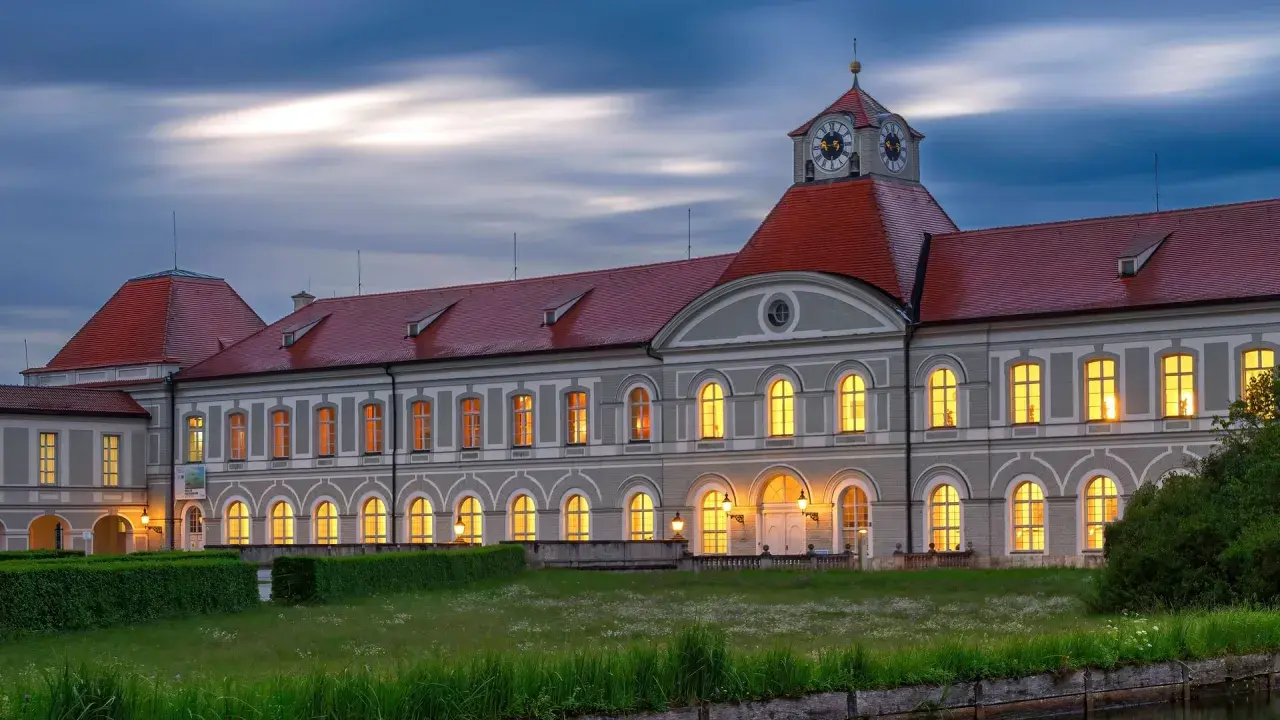 Prachtvolles Haus Bayern mit roten Dächern und beleuchteten Fenstern im Abendlicht. Ein märchenhaftes Schloss in Bayern.