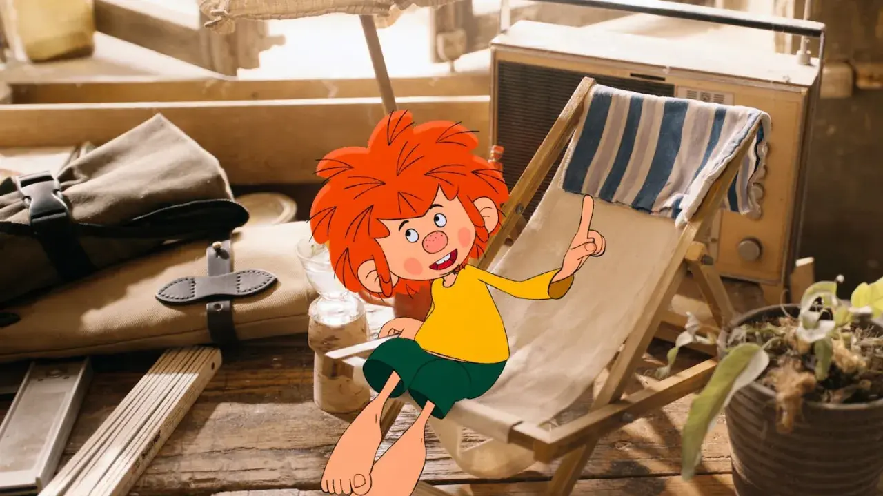 Der kleine Kobold Pumuckl sitzt auf einem Liegestuhl, die Sonne scheint. Ein altes Radio steht daneben.