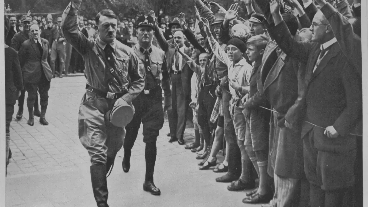 Adolf Hitler und Parteigenossen grüßen die Menge. Ein Bild, das den Aufstieg der NSDAP dokumentiert.