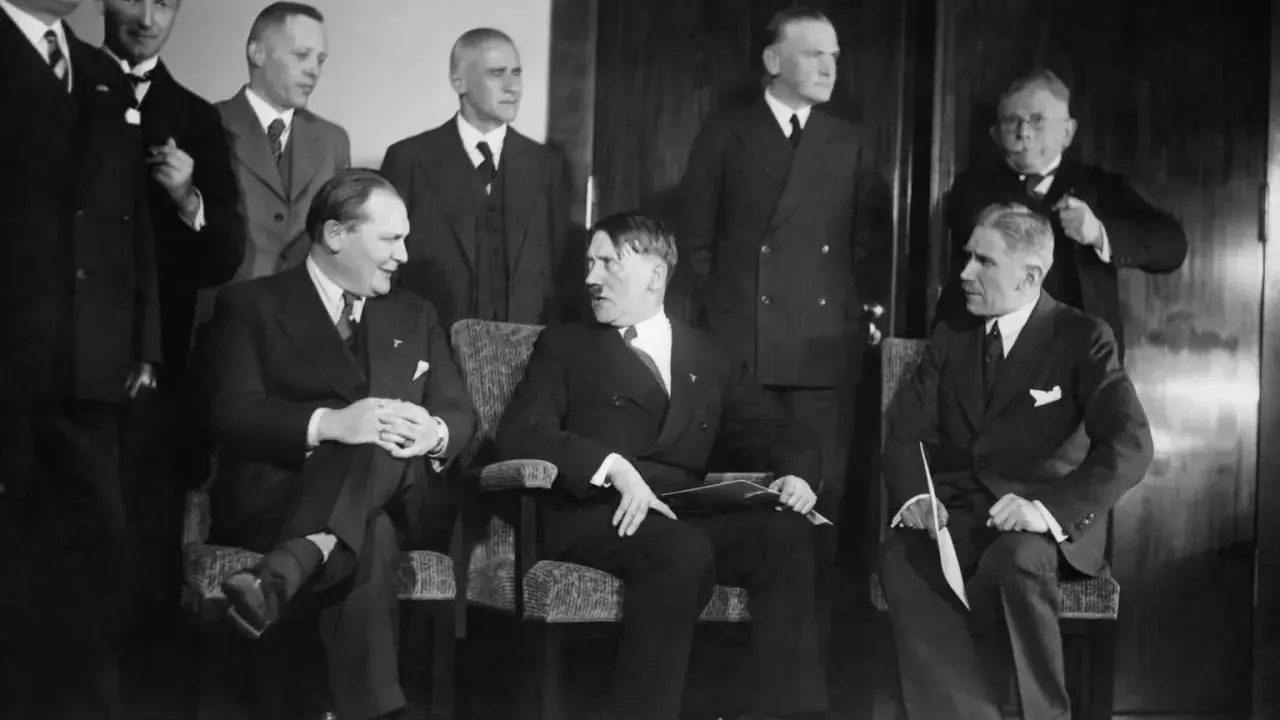 Am 30. Januar 1933: Hitler und seine Gefolgschaft, eine Gruppe von Männern in Anzügen, sitzen und stehen in einem Raum.