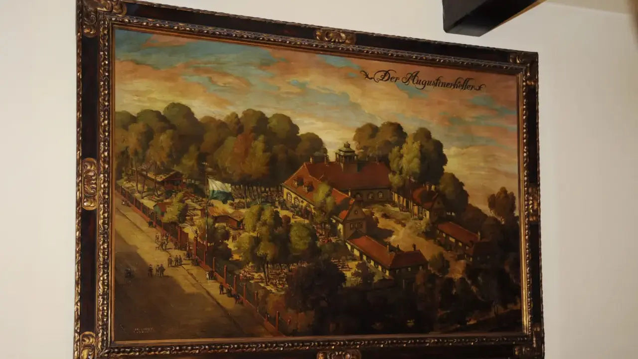 Gemälde von Josef Wagner: "Der Augustinerkeller" mit Menschen, Bäumen und Gebäuden.