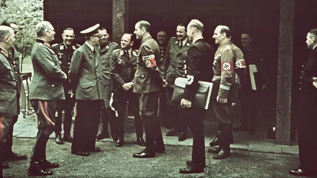 Männer in Uniformen, einige mit Hakenkreuz-Armbinden, stehen im Freien. Die Frage, wo hat Hitler gewohnt, wird hier nicht beantwortet.