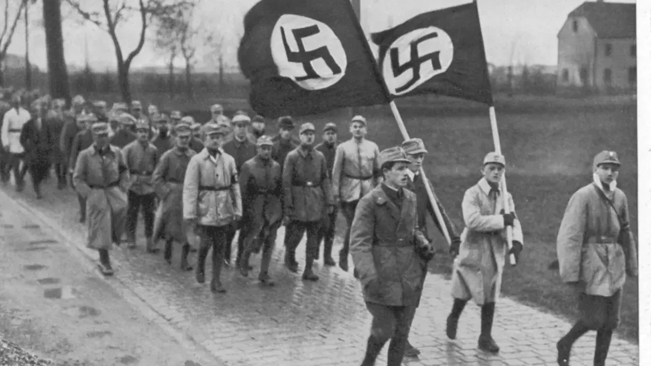 Männer marschieren mit Hakenkreuzfahnen. Ein historisches Bild, das an den Putschversuch Hitlers erinnert.