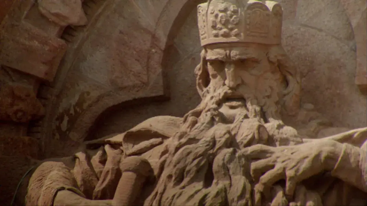 Steinskulptur von Friedrich I. Barbarossa mit Krone und Bart, der auf einem Thron sitzt.