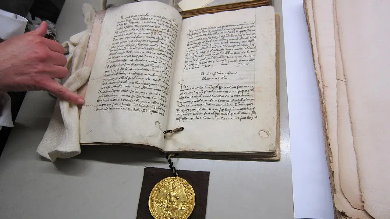 Goldene Bulle 1356: Offenes Buch mit Siegel und Hand.