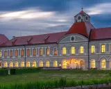 Prachtvolles Haus Bayern mit roten Dächern und beleuchteten Fenstern im Abendlicht. Ein märchenhaftes Schloss in Bayern.