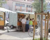 Marktstände in Neukirchen Balbini mit Brot und Butter. Menschen kaufen ein, ein Fahrrad steht bereit.