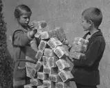 Kinder stapeln Bündel von Geldscheinen, ein Symbol für die Hyperinflation in Deutschland 1923.