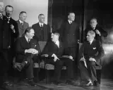 Am 30. Januar 1933: Hitler und seine Gefolgschaft, eine Gruppe von Männern in Anzügen, sitzen und stehen in einem Raum.
