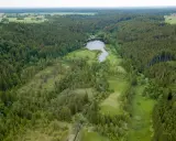 Luftaufnahme des Erdinger Mooses mit einem See und umliegenden Wäldern.