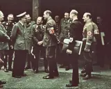 Männer in Uniformen, einige mit Hakenkreuz-Armbinden, stehen im Freien. Die Frage, wo hat Hitler gewohnt, wird hier nicht beantwortet.