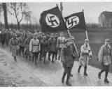 Männer marschieren mit Hakenkreuzfahnen. Ein historisches Bild, das an den Putschversuch Hitlers erinnert.
