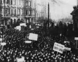 Massen demonstrieren in der Revolution 1918. Schilder mit Aufschriften wie "Seydlitz" und "Bleib ruhig" werden hochgehalten.