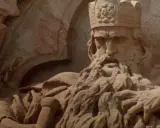Steinskulptur von Friedrich I. Barbarossa mit Krone und Bart, der auf einem Thron sitzt.