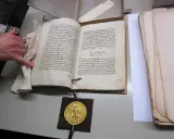 Goldene Bulle 1356: Offenes Buch mit Siegel und Hand.