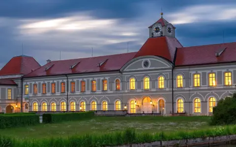 Prachtvolles Haus Bayern mit roten Dächern und beleuchteten Fenstern im Abendlicht. Ein märchenhaftes Schloss in Bayern.