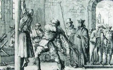 Ein Mann peitscht eine aufgehängte Frau, während Zuschauer, darunter Geistliche, zusehen. Eine Szene, die an die Schrecken der Hexenverbrennung erinnert.