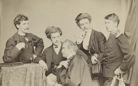 Fünf Männer posieren für ein Porträt. Einer von ihnen, vielleicht Franz Hanfstaengl, hält eine Mütze.