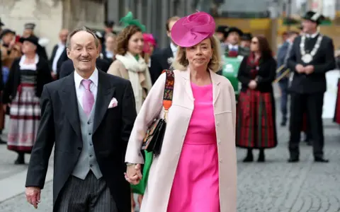Adalbert von Bayern und seine Frau, festlich gekleidet, gehen Hand in Hand.