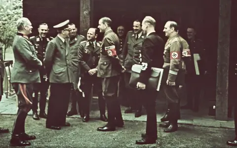Männer in Uniformen, einige mit Hakenkreuz-Armbinden, stehen im Freien. Die Frage, wo hat Hitler gewohnt, wird hier nicht beantwortet.