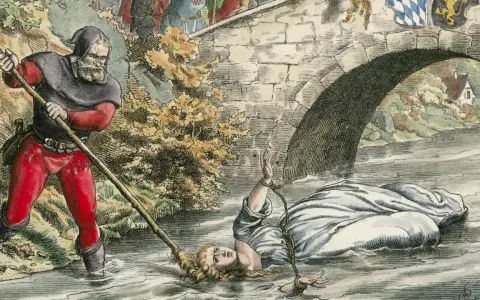 Eine Frau wird unter einer Brücke im Wasser gefesselt. Ein Mann mit Kapuze und roter Hose hält einen Stab. Dies ist eine Szene aus einer **Hexenverfolgung Karte**.