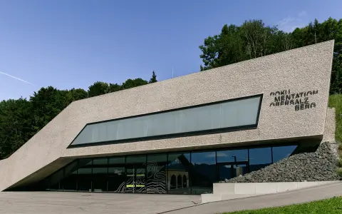 Dokumentation Obersalzberg, ein Ort, der mit Hitler verbunden ist, mit moderner Architektur und Blick auf die Berge.