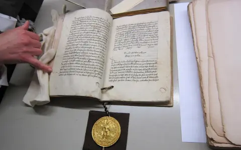 Goldene Bulle 1356: Offenes Buch mit Siegel und Hand.