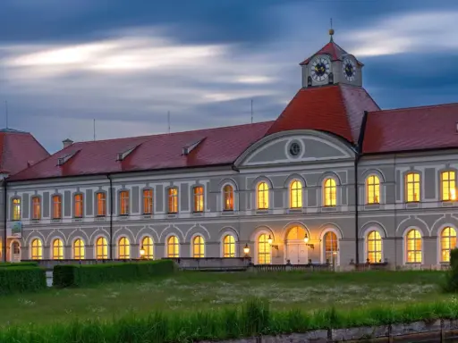 Prachtvolles Haus Bayern mit roten Dächern und beleuchteten Fenstern im Abendlicht. Ein märchenhaftes Schloss in Bayern.