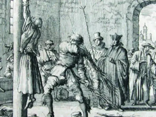 Ein Mann peitscht eine aufgehängte Frau, während Zuschauer, darunter Geistliche, zusehen. Eine Szene, die an die Schrecken der Hexenverbrennung erinnert.