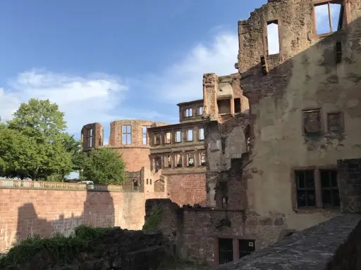 Ruinen des Heidelberger Schlosses, einst Sitz von Friedrich V. Ein Baum und blauer Himmel mit Wolken.