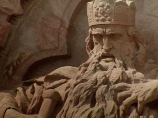 Steinskulptur von Friedrich I. Barbarossa mit Krone und Bart, der auf einem Thron sitzt.