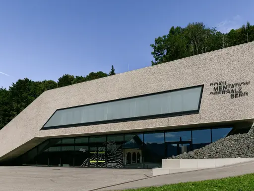 Dokumentation Obersalzberg, ein Ort, der mit Hitler verbunden ist, mit moderner Architektur und Blick auf die Berge.