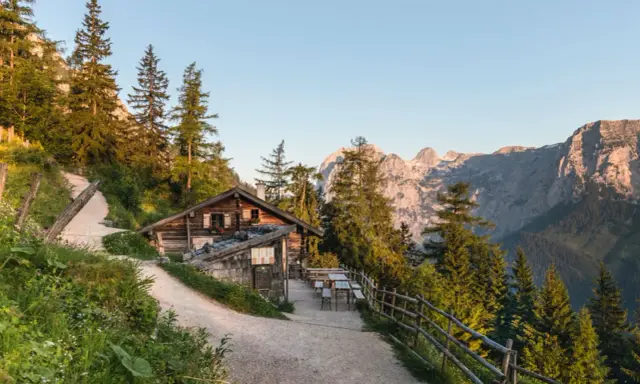 Eine urige Hütte auf einer Alm mit Bergpanorama. Hier kann man erleben, was eine Alm ist: ein Ort der Ruhe und Natur.