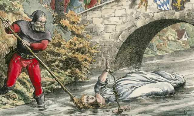 Eine Frau wird unter einer Brücke im Wasser gefesselt. Ein Mann mit Kapuze und roter Hose hält einen Stab. Dies ist eine Szene aus einer **Hexenverfolgung Karte**.
