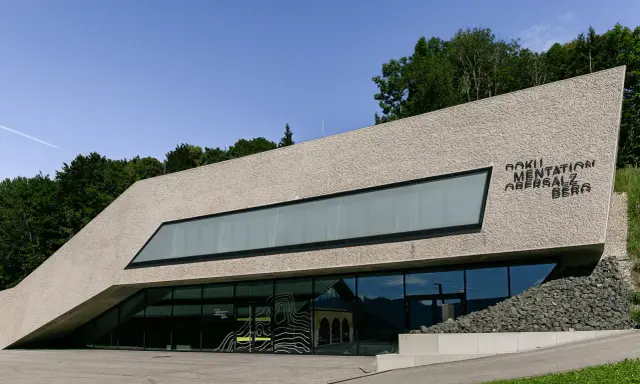 Dokumentation Obersalzberg, ein Ort, der mit Hitler verbunden ist, mit moderner Architektur und Blick auf die Berge.