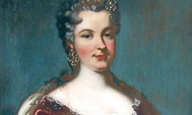 Porträt einer Frau mit Krone und Schmuck, die ein prunkvolles Kleid trägt.