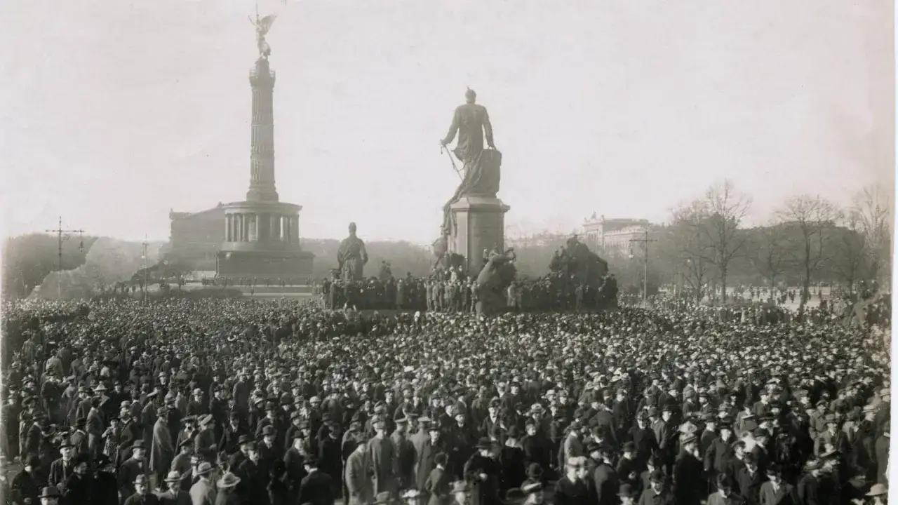 Menschenmenge vor dem Siegessäule-Denkmal in Berlin, ein Symbol der revolutionären Stimmung der Revolution 1918.