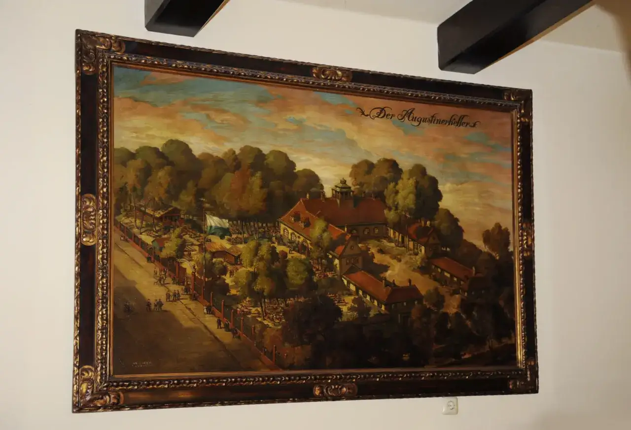 Gemälde von Josef Wagner: Der Augustinerkeller mit vielen Menschen, Bäumen und Gebäuden unter einem dramatischen Himmel.