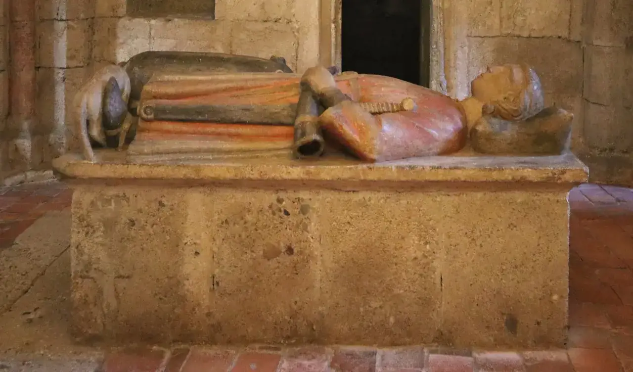 Grabmal eines Herzogs von Bayern, 794. Die Skulptur zeigt eine liegende Figur mit Schwert und Hund.