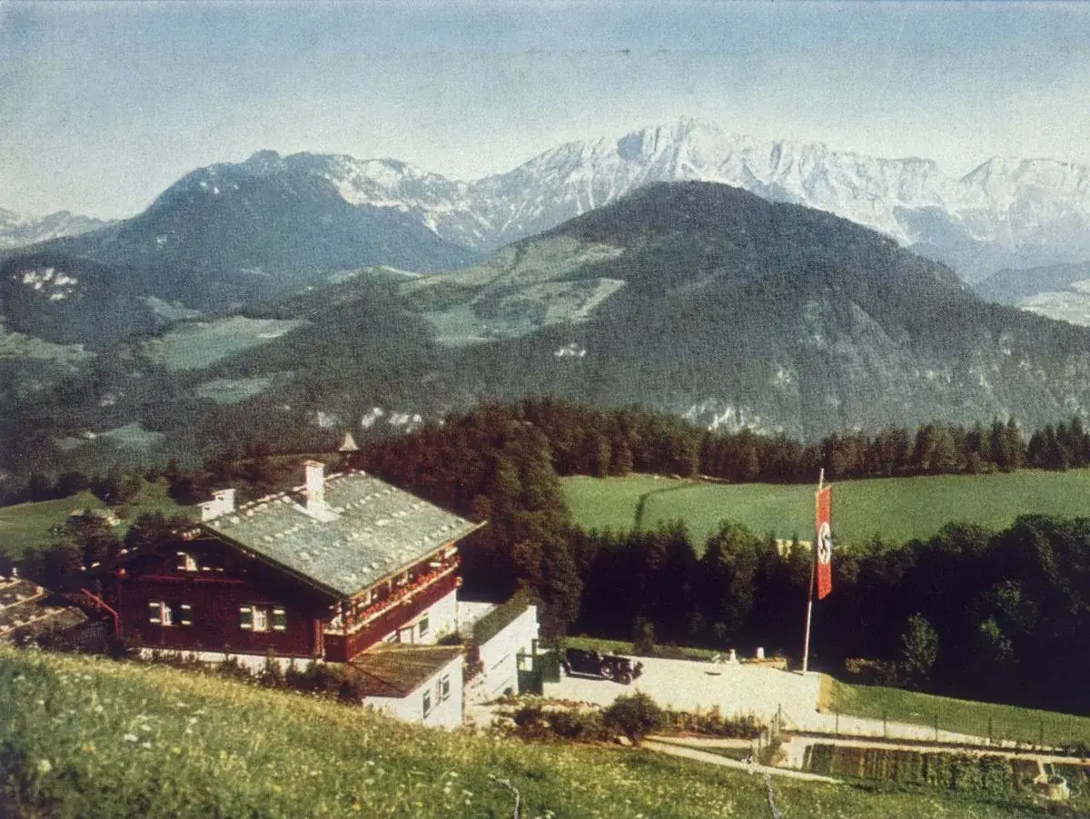 Bergpanorama mit einem Haus, das als Hitlers Residenz diente. Eine Hakenkreuzfahne weht im Wind.