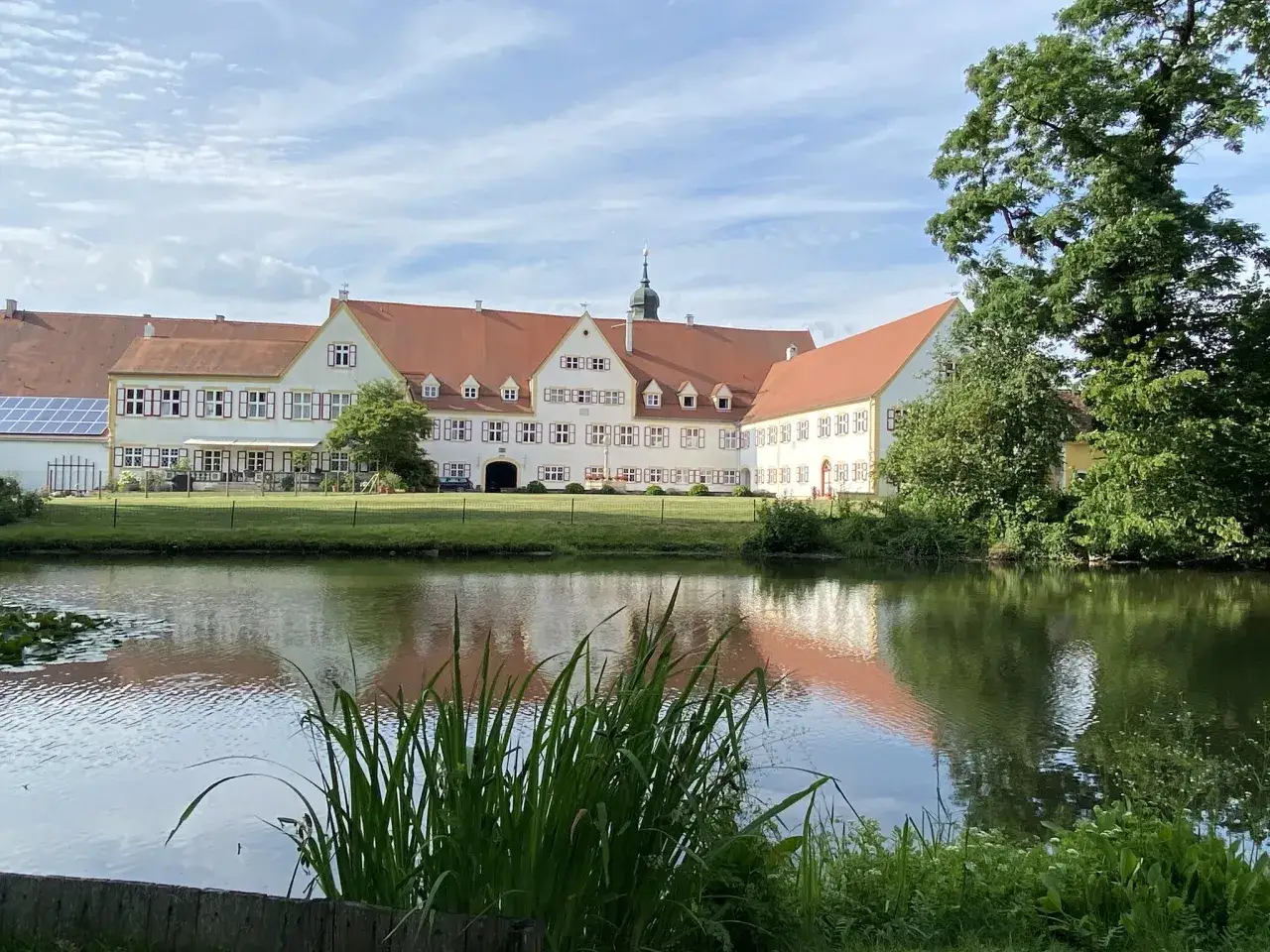 Schlossgut, einst im Besitz von Freiherr von Gumppenberg, spiegelt sich im Teich.