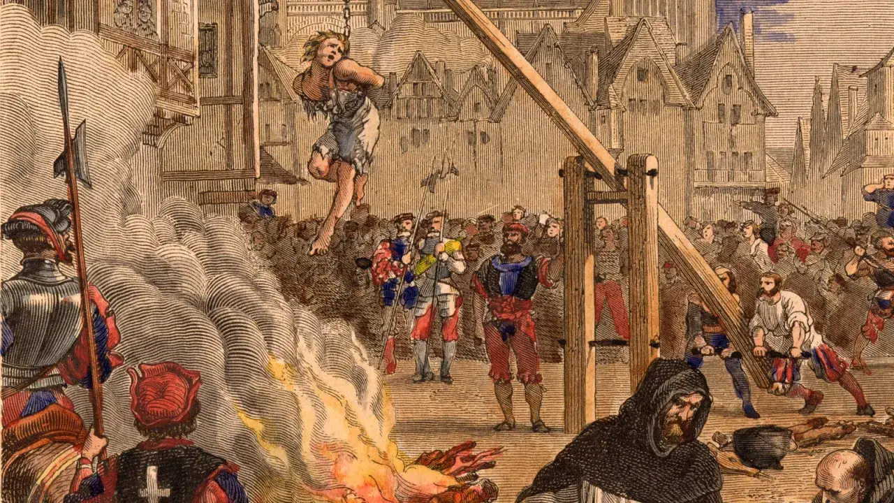 Eine grausame Szene der Inquisition: Eine Frau h&auml;ngt am Galgen, w&auml;hrend ein Feuer lodert. Die Hexenverfolgung fordert Opfer.