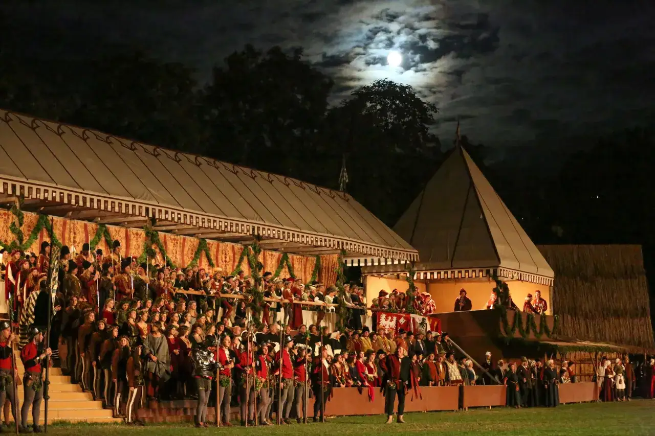Große Menschenmenge in historischen Kostümen bei der Landshuter Hochzeit unter dem Mond.